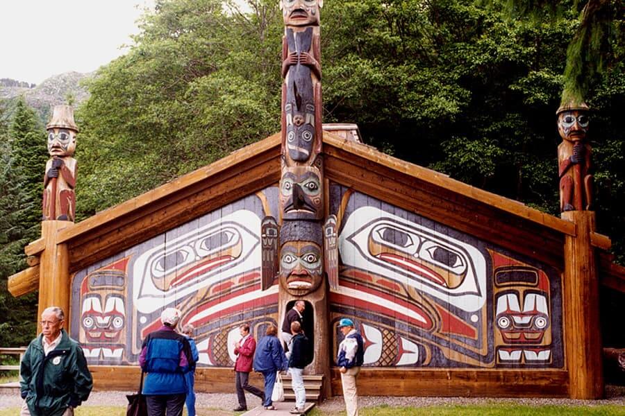 people visiting a large totem pole display