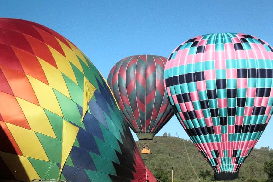 a group of hot air balloons beginning to rise up in the air
