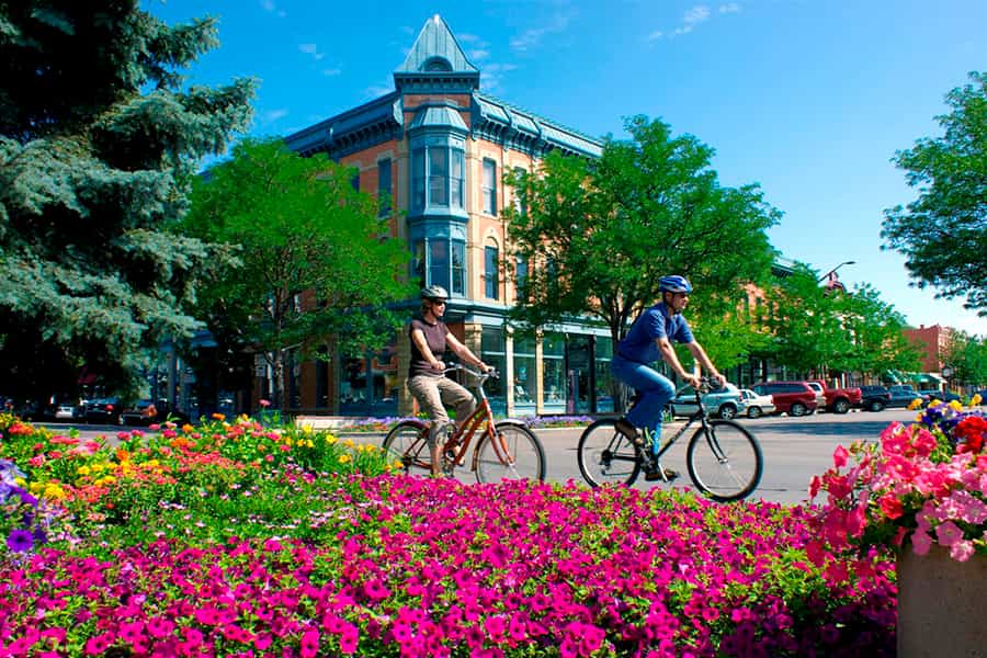 a couple biking through the downtown of fort collins