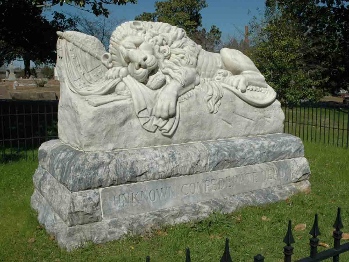 an ornate headstone of a sleeping lion at the oakland cemetery