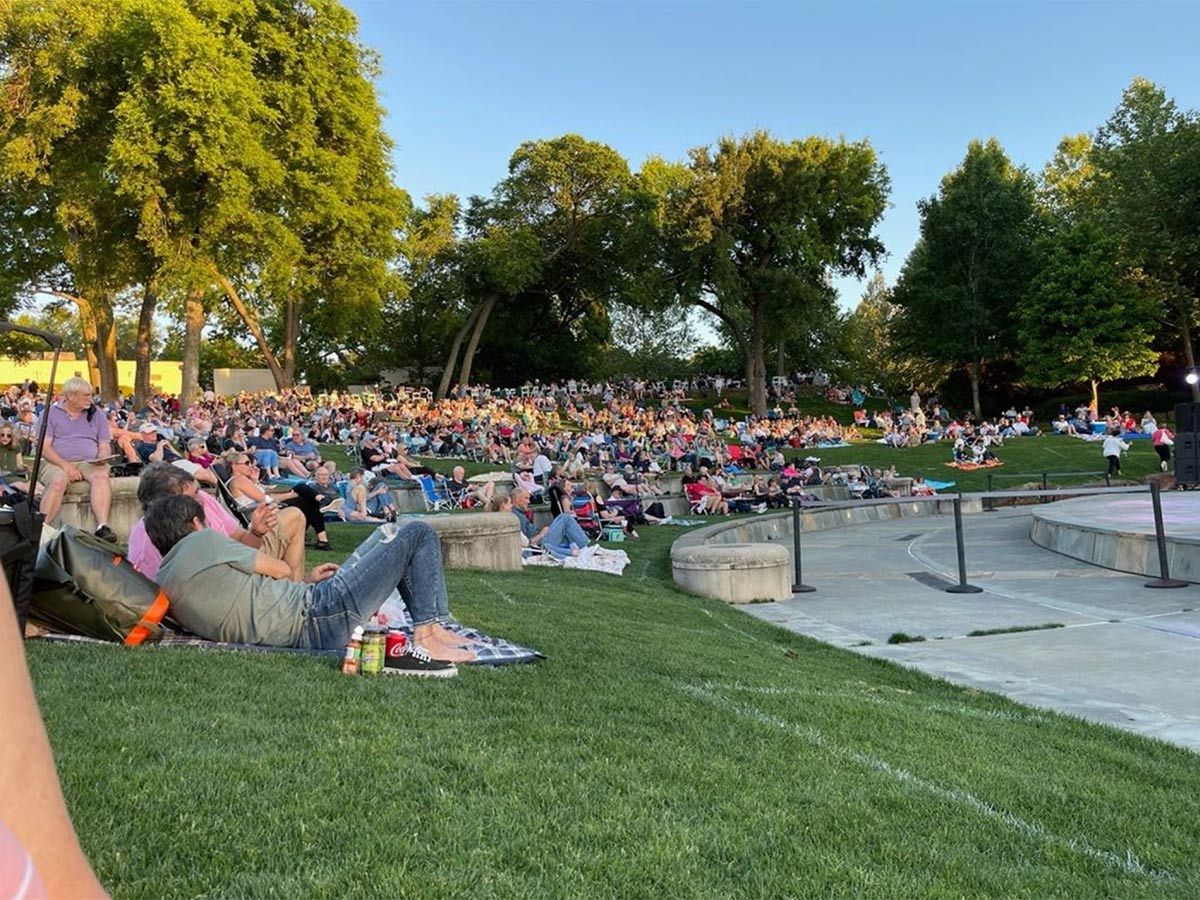 concert goers on a lawn enjoying some music