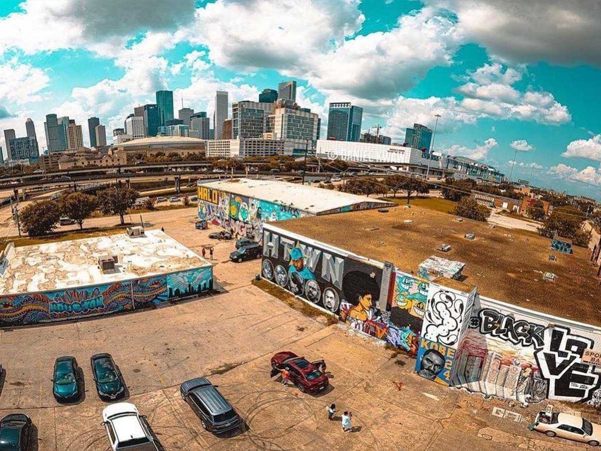 walls covered in graffiti art with the houston skyline in the background