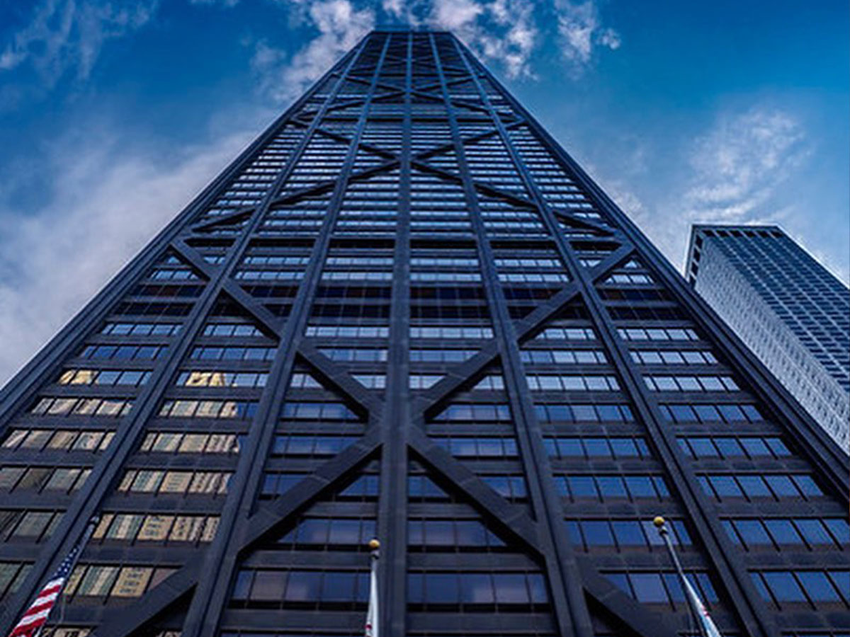 a view looking up the john hancock center building from street level