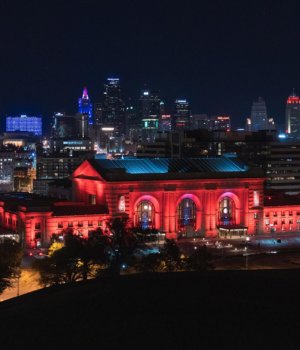 union station in kansas city lit up in red lights at night