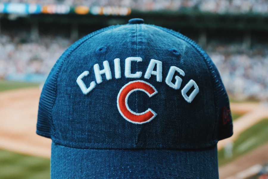 a chicago cubs hat with wrigley field in the background