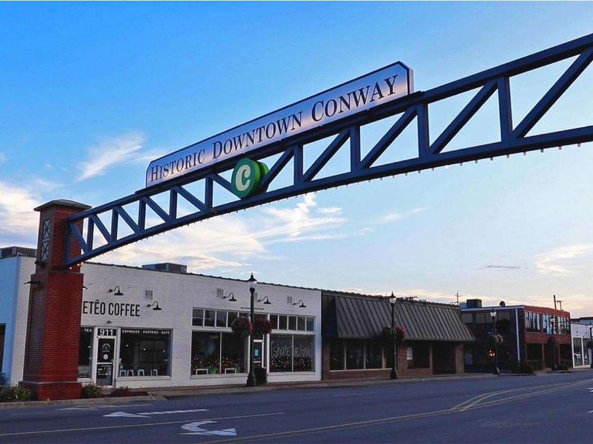 an arch sign that says historic downtown conway