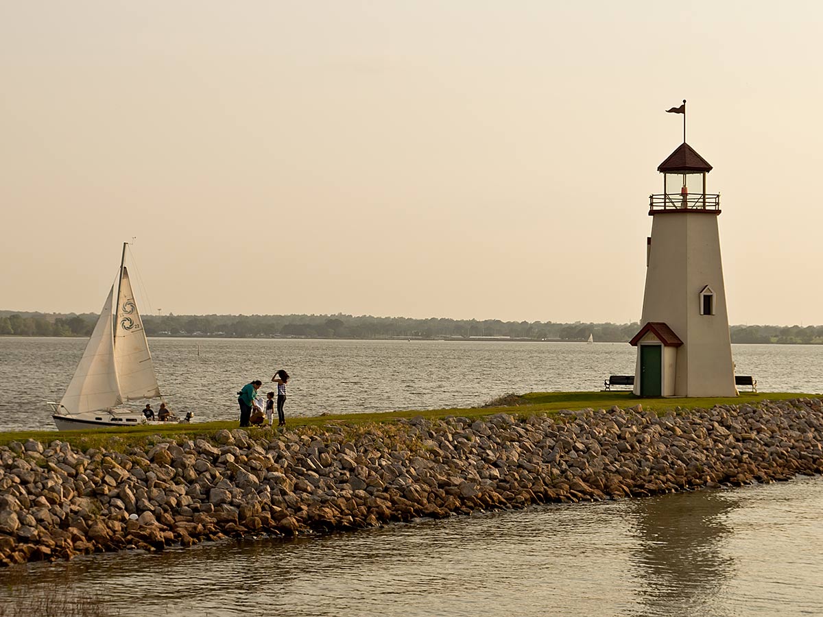 a sailboat and lighthouse on lake hefner