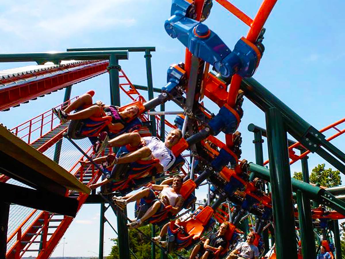 people ride a roller coaster at six flags frontier city theme park