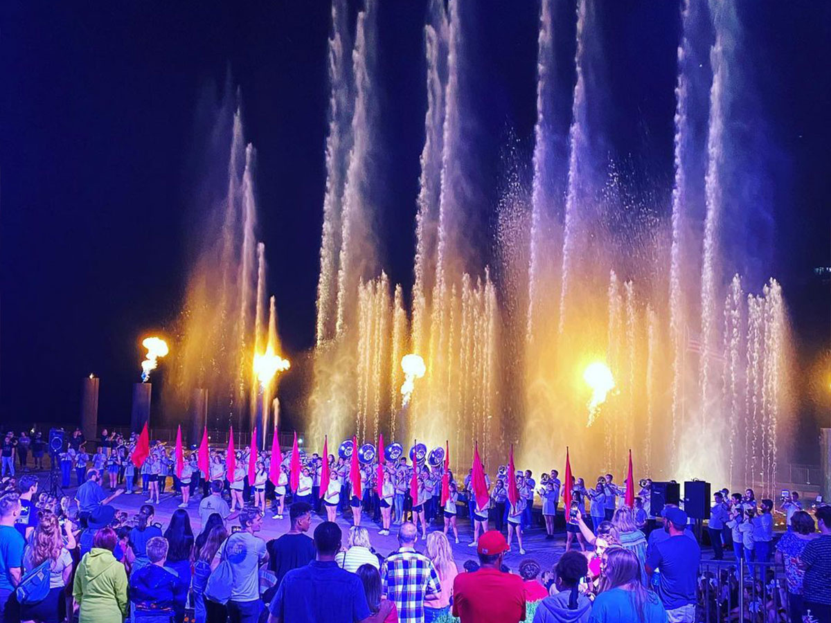 the branson landing fountains splash high behind a musical performance on the stage