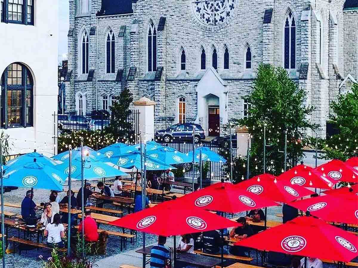 an outdoor biergarten covered in colorful umbrellas at urban chestnut brewing company