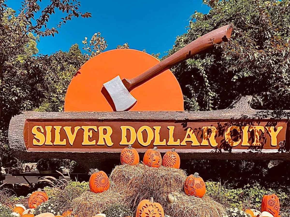 the entrance sign to silver dollar city surrounded by carved pumpkins in fall