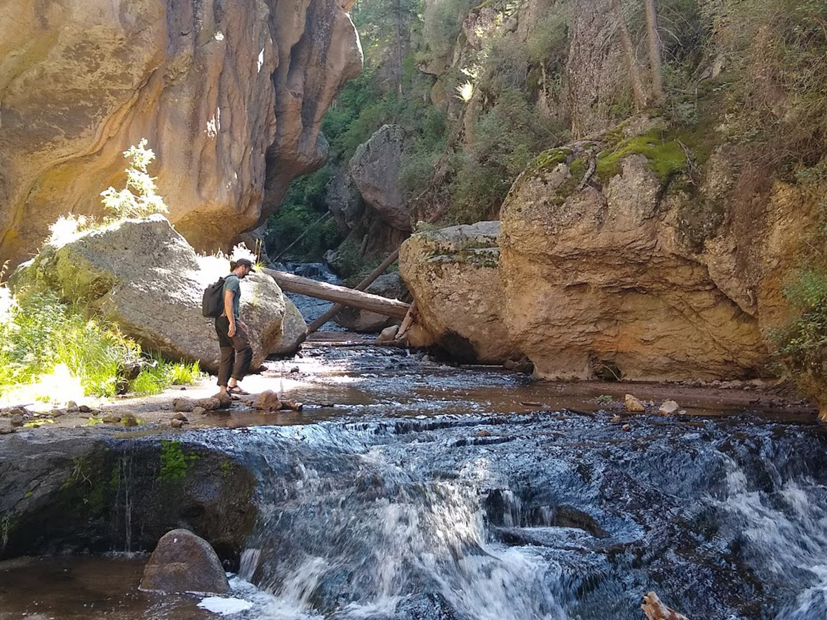 a hiker standing in a stream of water in the Jemez Mountains