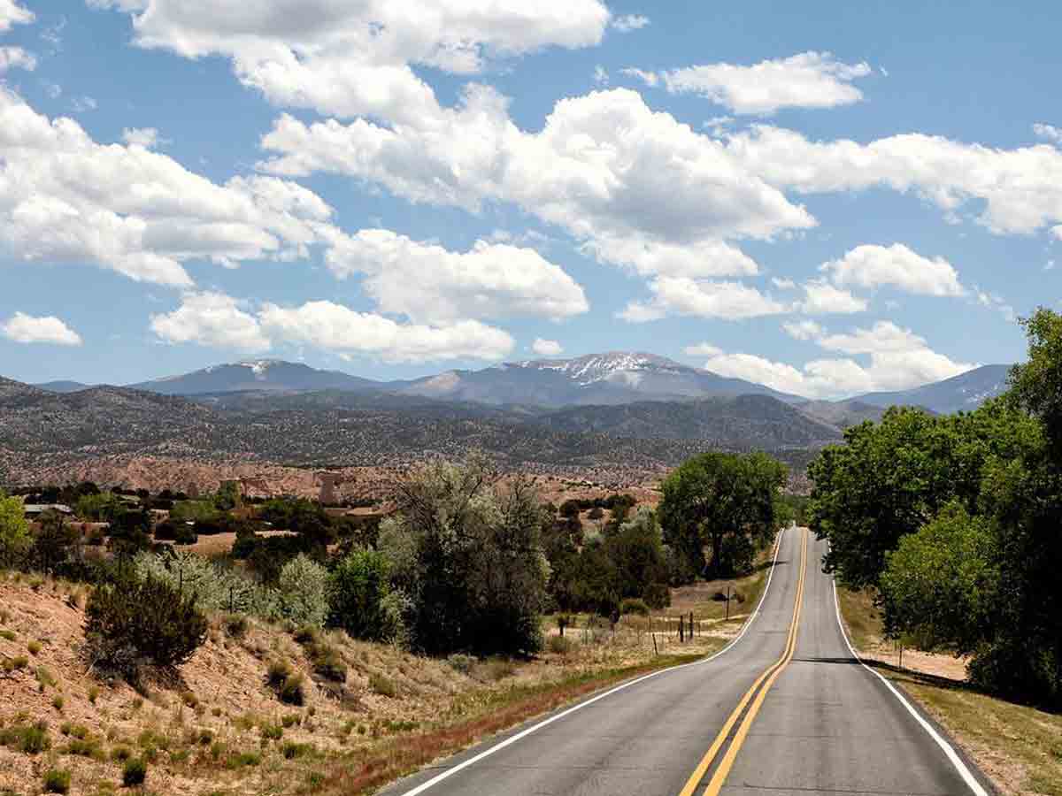 a landscape view of a roadway known as the high road between santa fe and taos