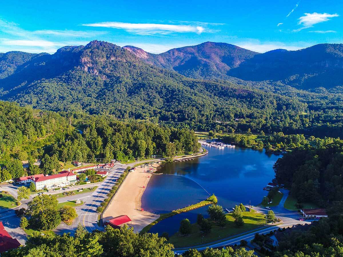 a drone view of lake lure in north carolina with mountains in the background