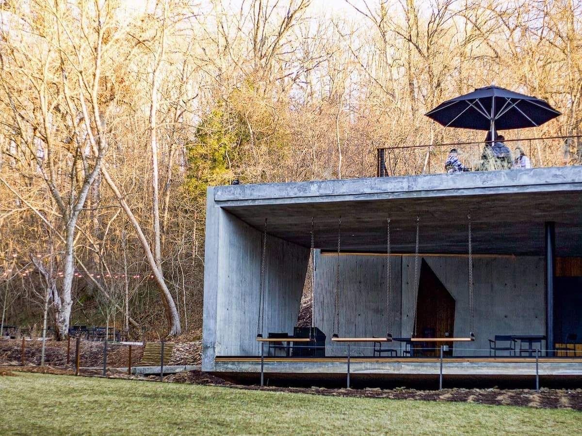 a modern concrete cafe along a bike trail in the woods operated by airship coffee in northwest arkansas