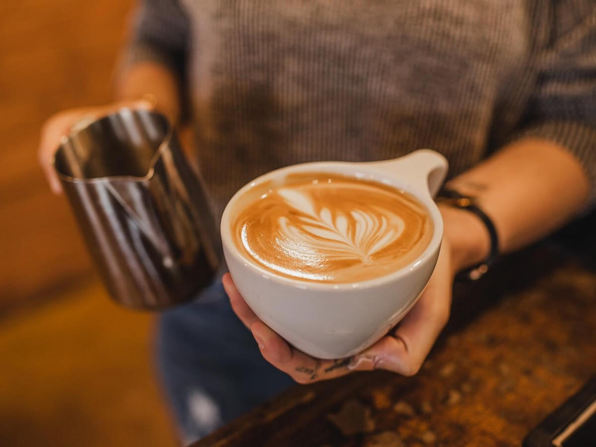 a barista holds a latte at monticello coffee company in monticello arkansas