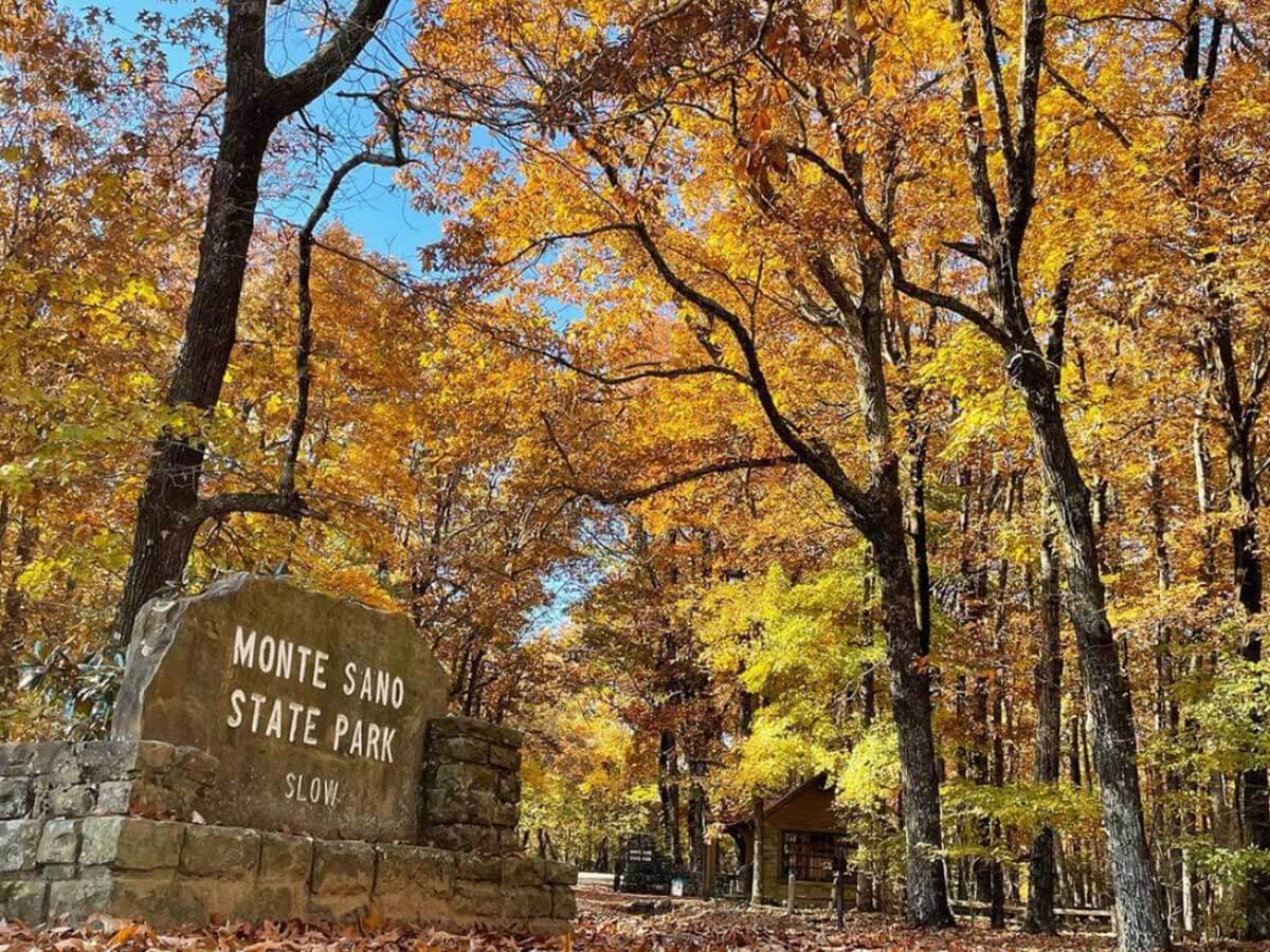 an entrance sign to monte sano state park in alabama surrounded by colorful yellow and orange trees