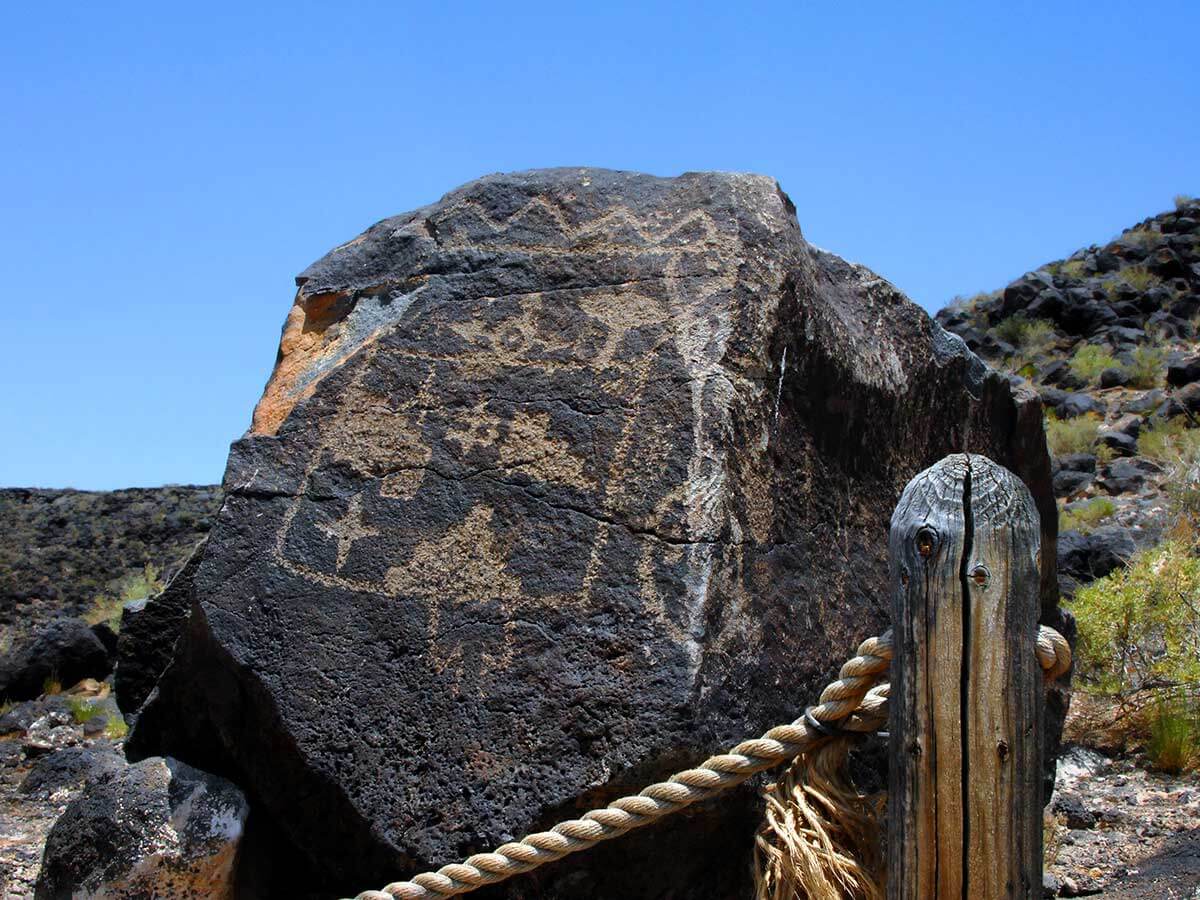 historic carvings in a black rock at petroglyph national monument
