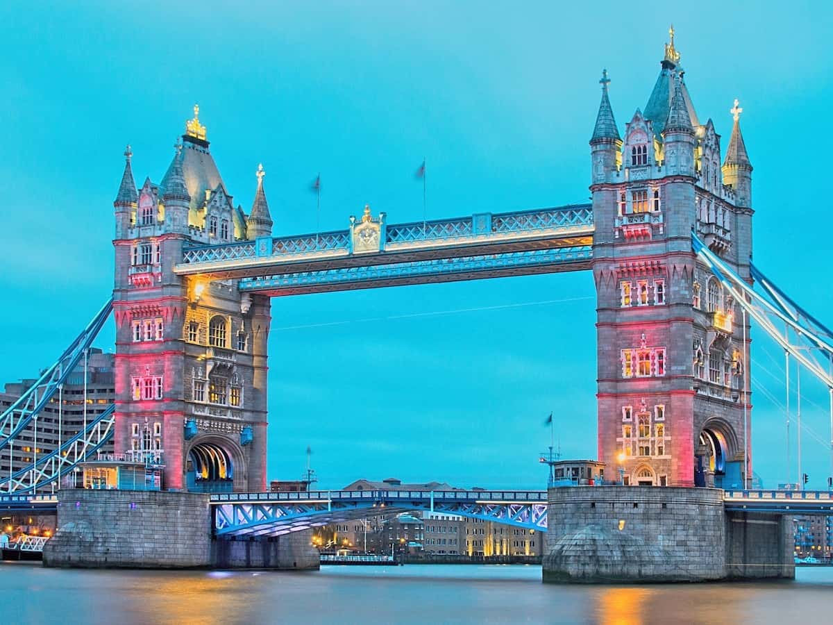 colorful lights are shown on tower bridge on the river thames