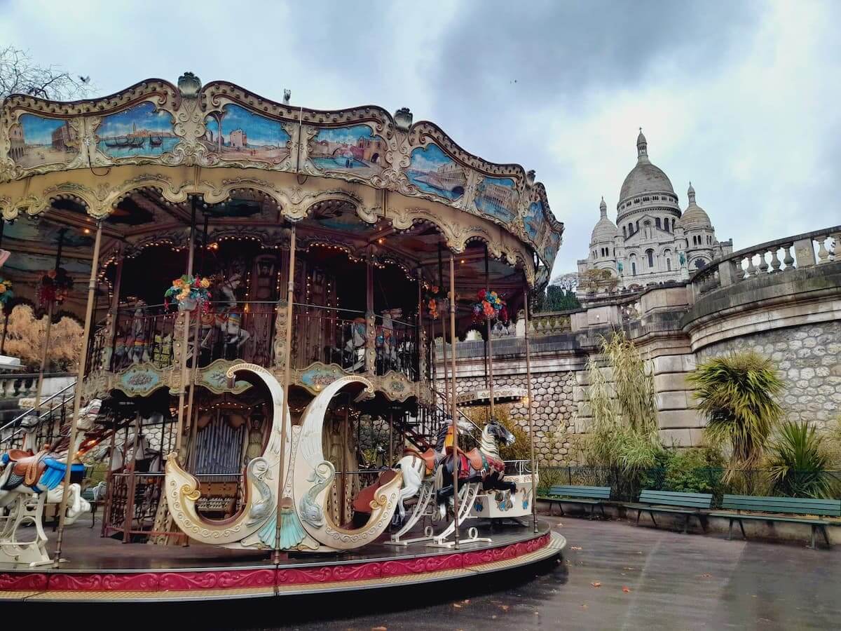 the carrousel de saint-pierre at the foot of sacre-coeur in the distance
