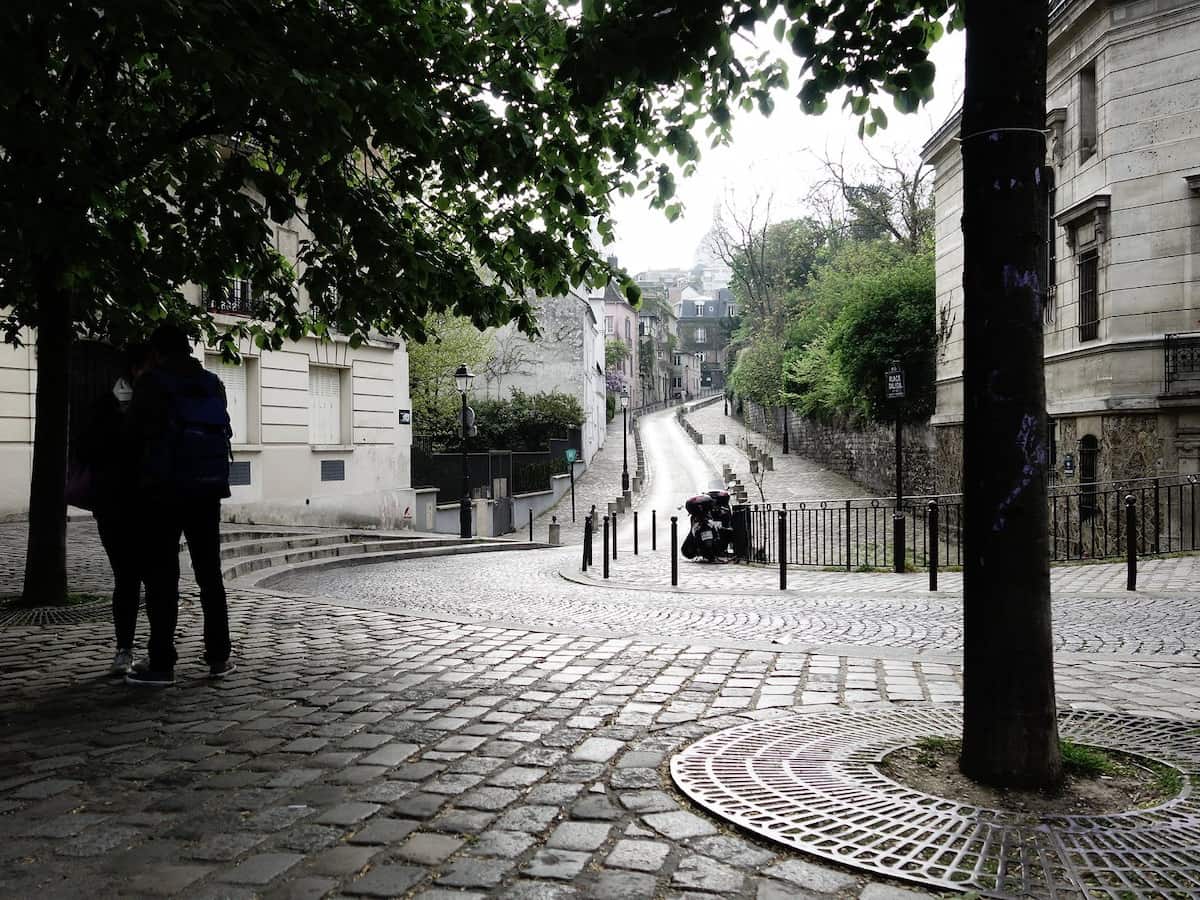a view down the cobblestone streets surrounding place delida in paris