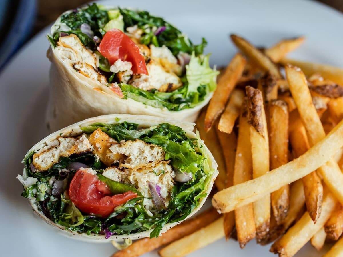 a sandwich wrap and french fries at a vegan restaurant in denver colorado