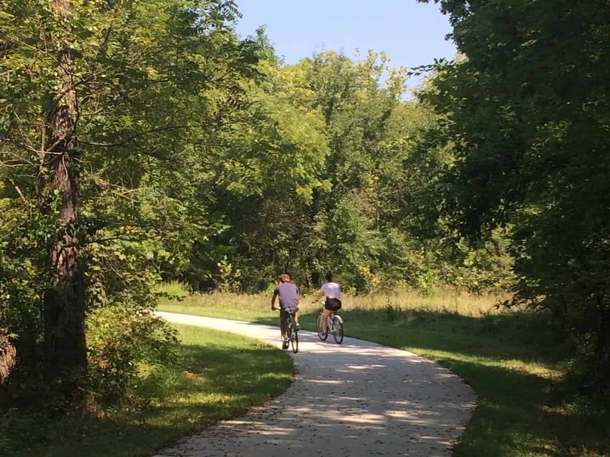 a couple biking through green landscape along the lawrence loop trail