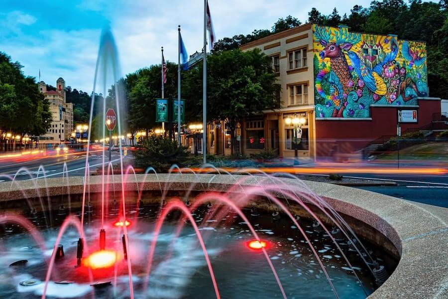 a fountain in downtown hot springs with a colorful mural in the background