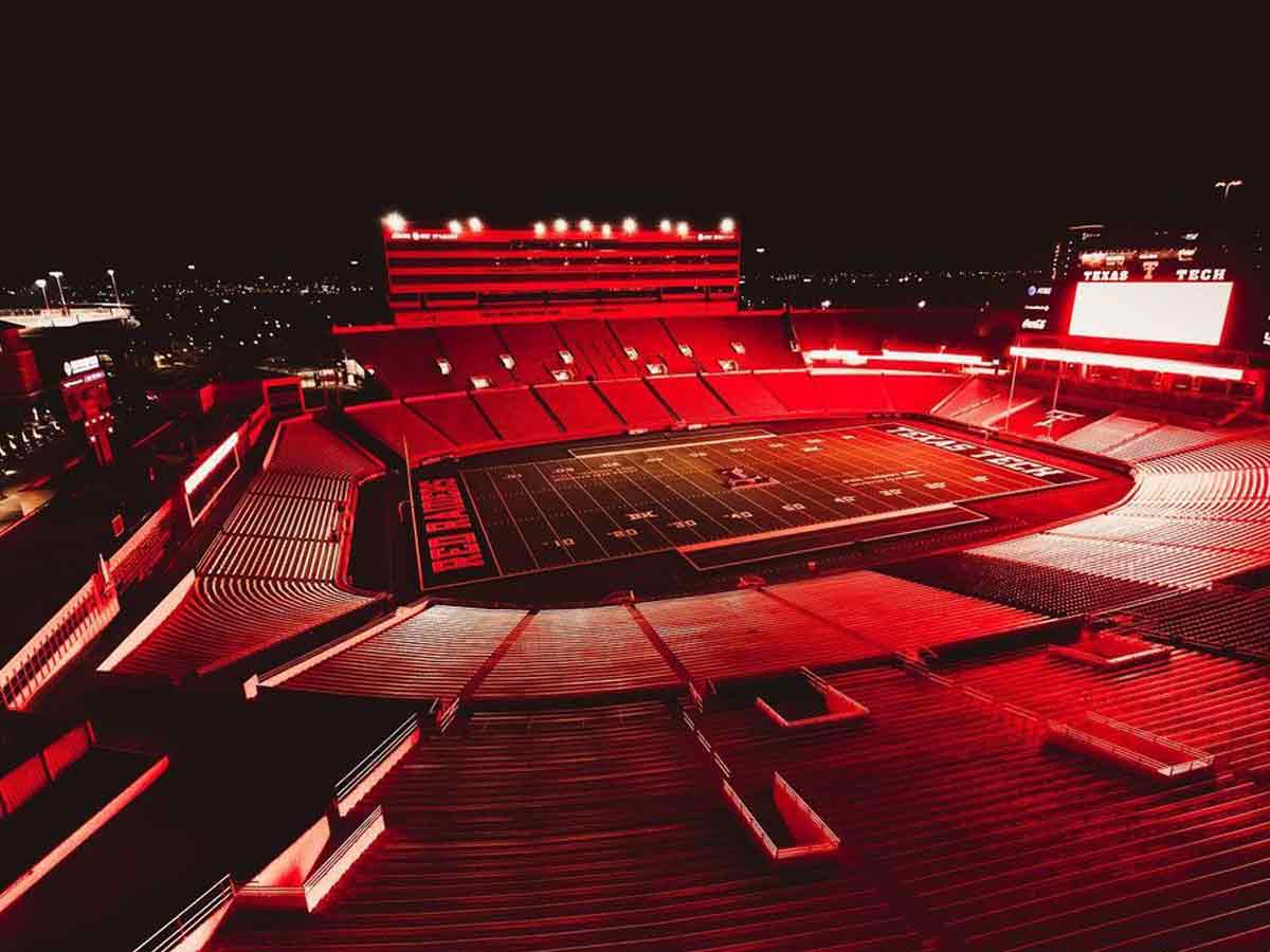 the texas tech football stadium lit up in red lights at night
