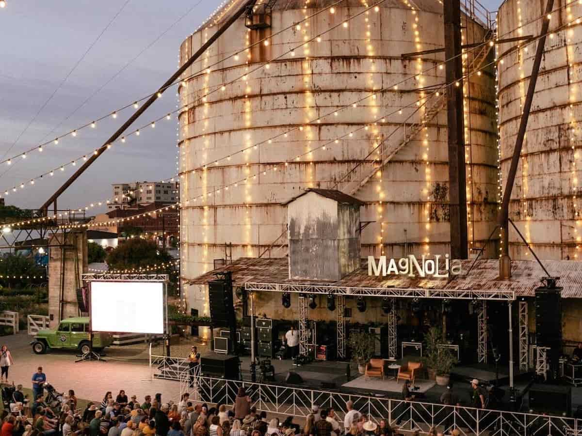 an aerial view of the magnolia silos lit up in lights with a stage set up in front of them