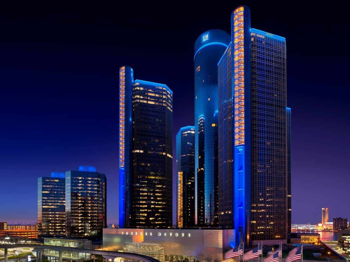 the multiple tall buildings of the renaissance center in detroit lit up at night in blue lights