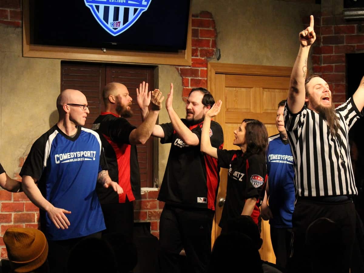 a group of comedians performing at comedysports in milwaukee