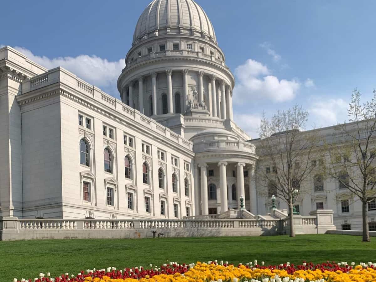 a view of the wisconsin state capitol building in madison with colorful spring flowers in the foreground