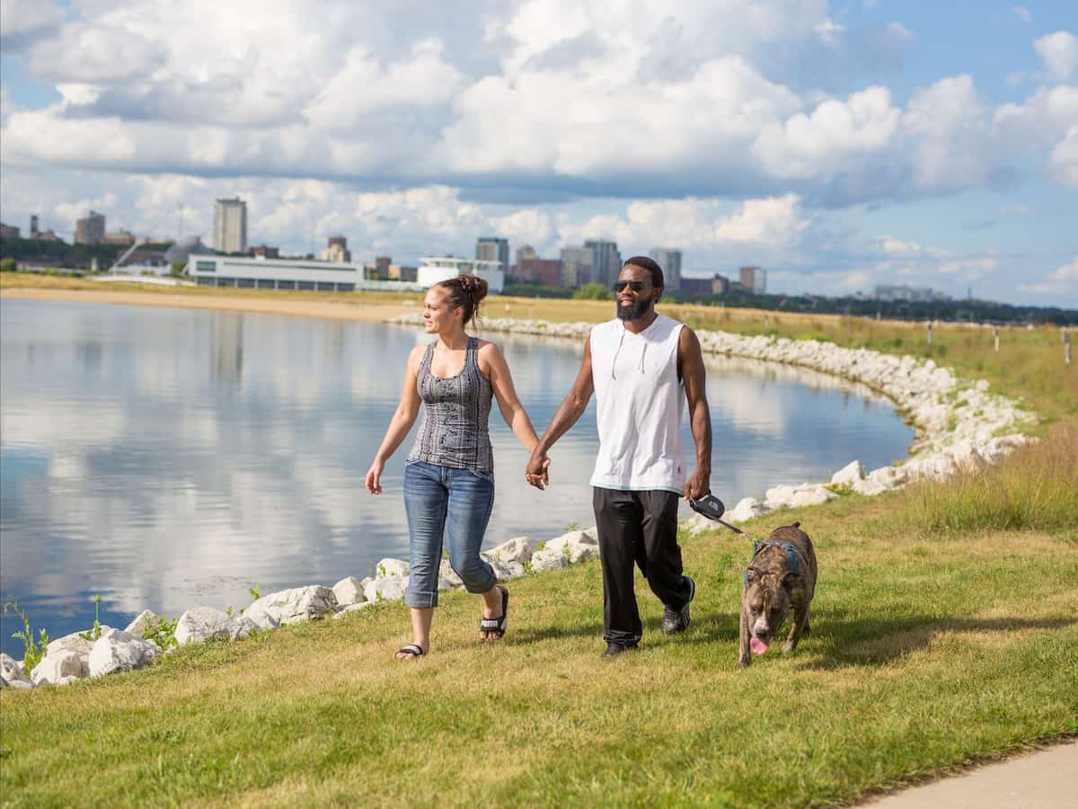 a couple walks their dog by veterans park pond