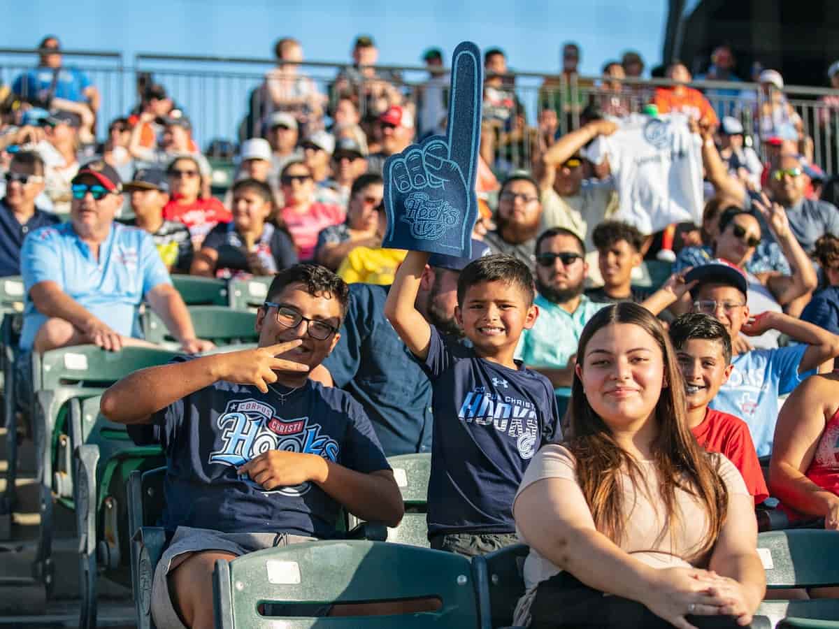 fans smile and wave at a corpus christi hooks baseball game