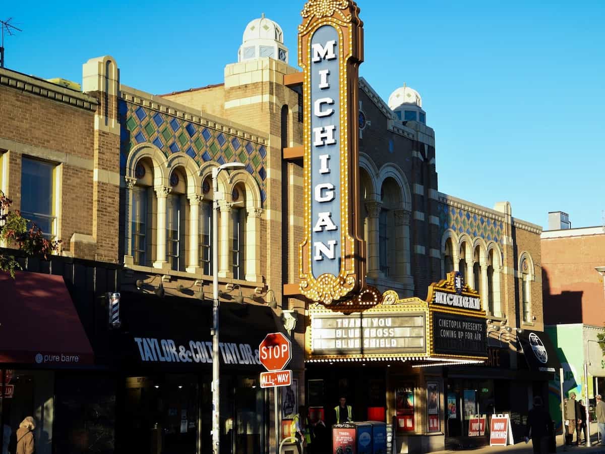 the exterior of the michigan theater with the namesake marquee