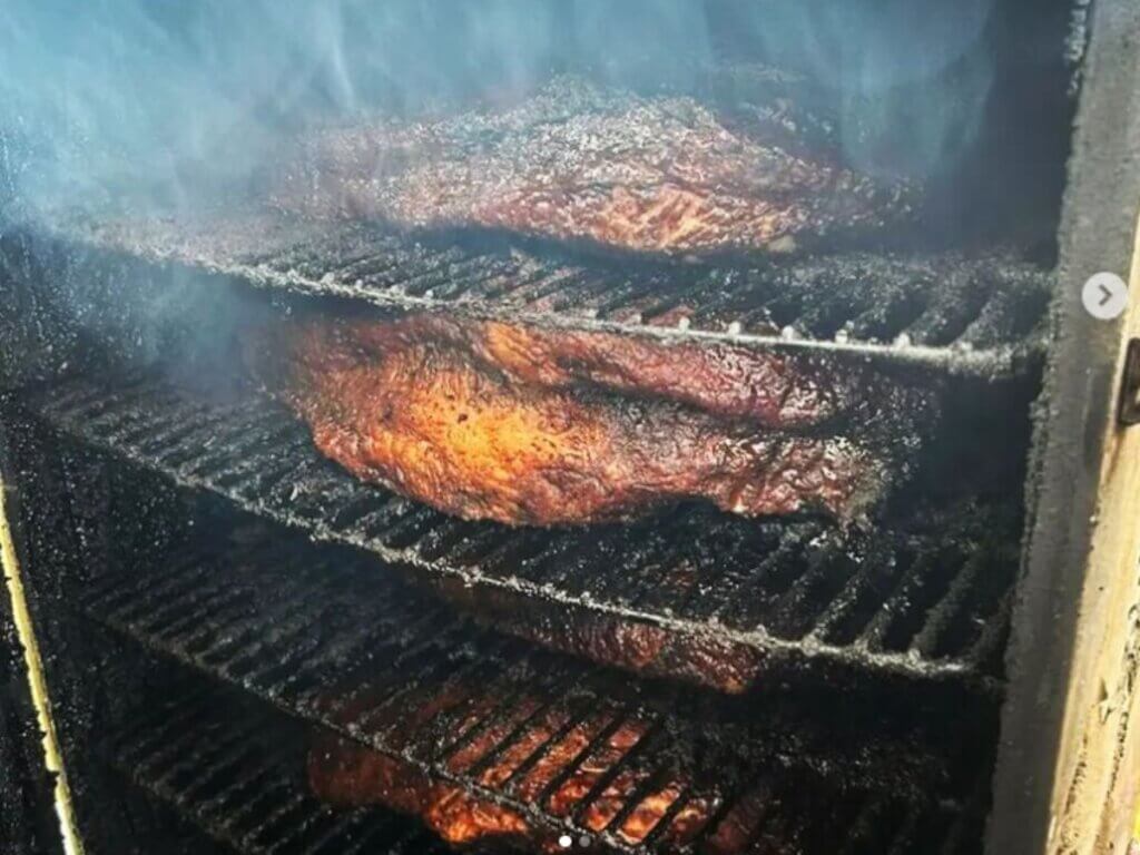 View of meat in the smoker at Holy Smokes BBQ and Catering