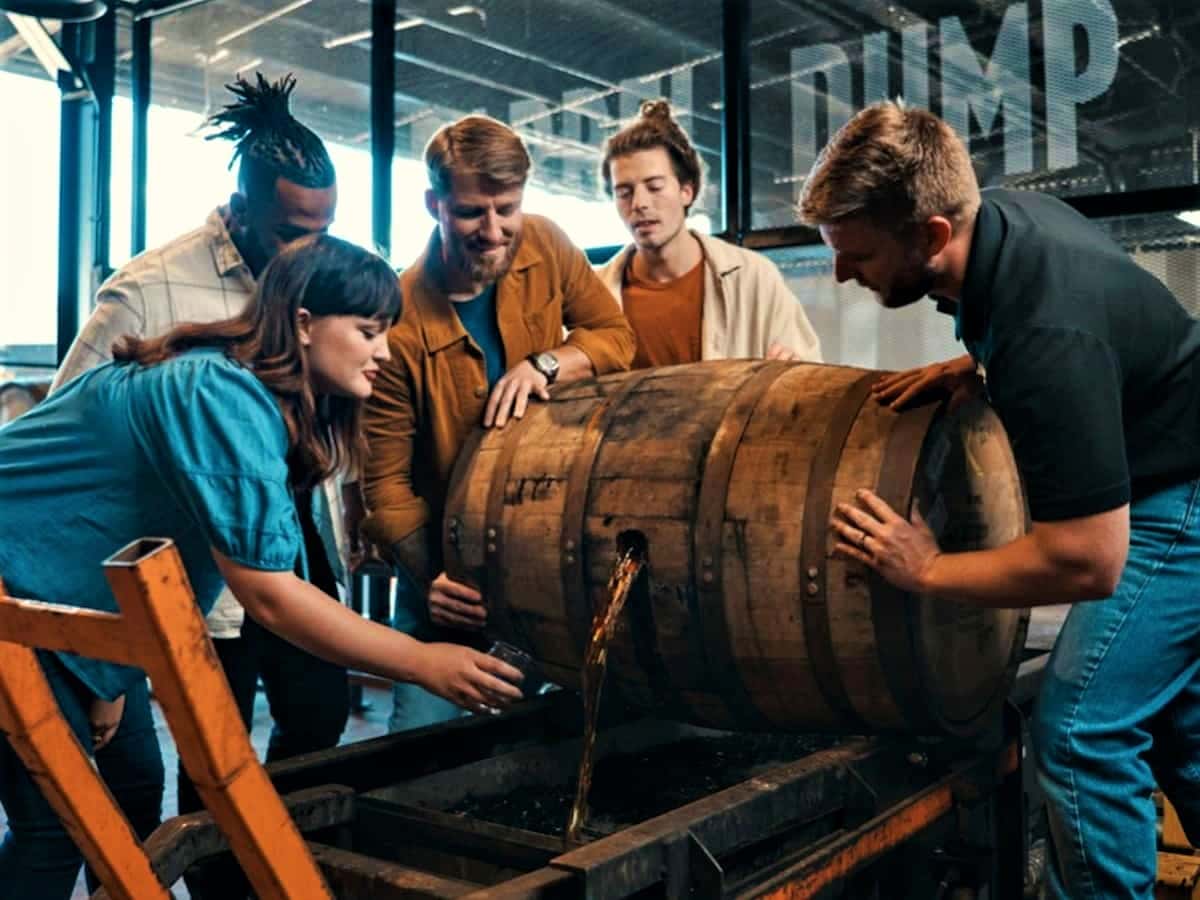 a group of visitors empty a bourbon casket at a kentucky distillery