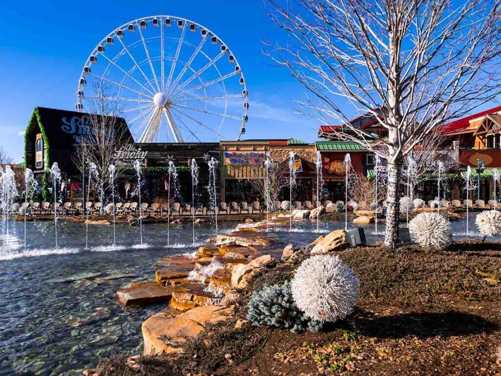 View of a ferris wheel, fountains, and buildings at the Island in Pigeon Forge