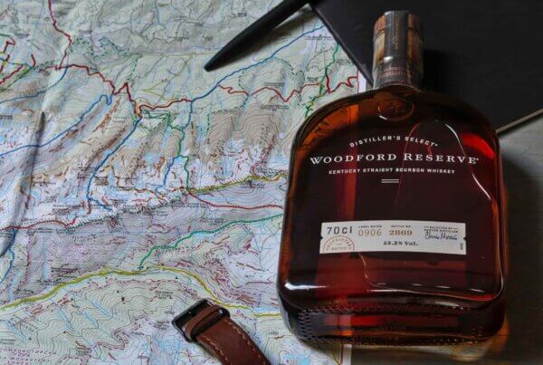 a bottle of woodford reserve bourbon whiskey lying on top of a map of kentucky