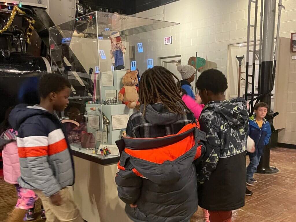 Kids standing around an exhibit at the Augusta Museum of History
