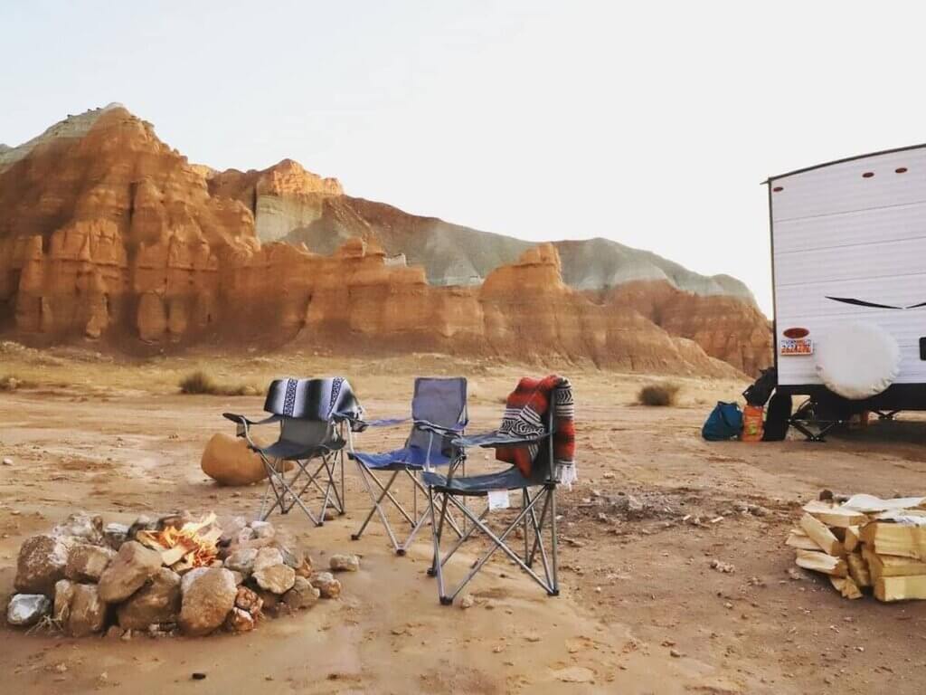 a campsite set up around a fire and an RV near moab utah