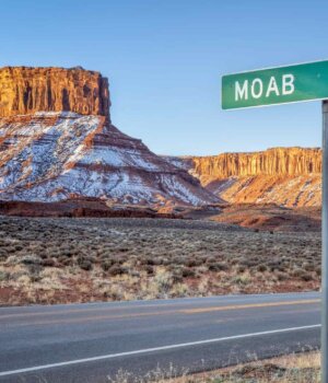 a snowy desert landscape with a street sign that says "Moab" on it
