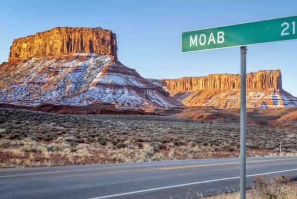 a snowy desert landscape with a street sign that says "Moab" on it