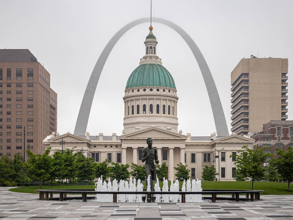 Symmetrical view of the arch, building, and fountains in St. Louis.