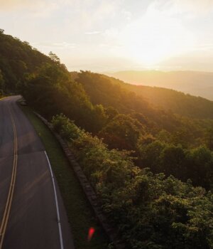 a sunset along a winding mountainous forested drive near asheville north carolina