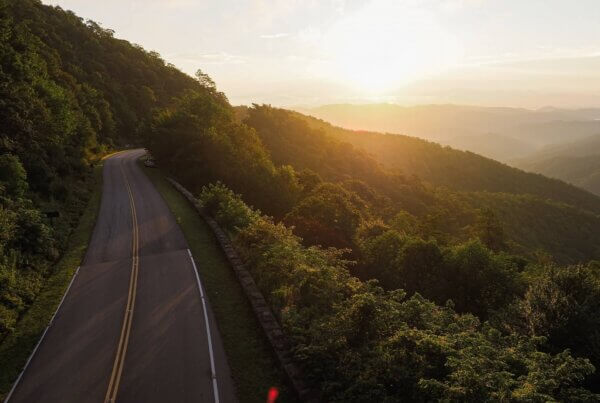 a sunset along a winding mountainous forested drive near asheville north carolina