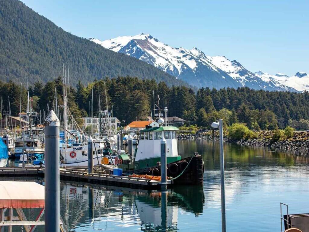 Boats in the water at Sitka with a snow-capped mountain in the background.