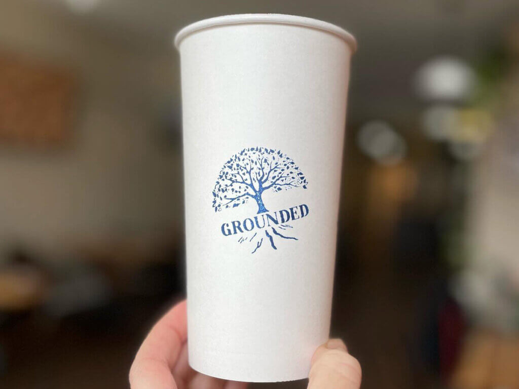 Person holding Grounded customized cup from Grounded Coffee - Geneva, NY
