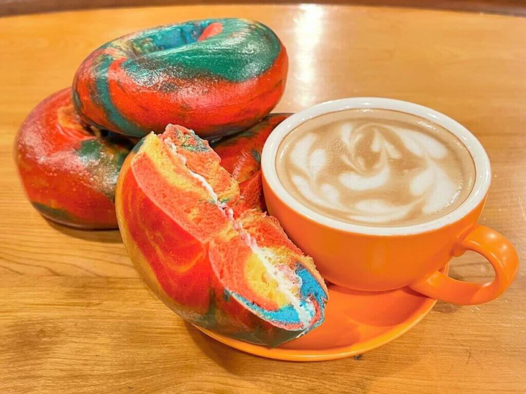 Latte served with colorful rainbow bagels at the coffeeshop Soul Full Cup - Corning, NY